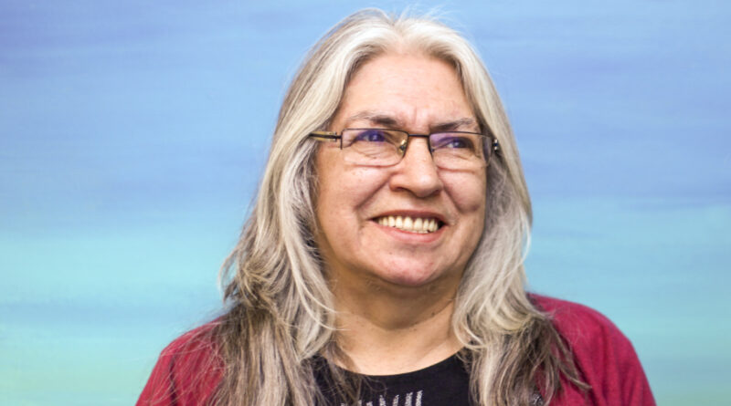 Lee Maracle wears wire glasses and smiles while looking slightly to the right of the camera.