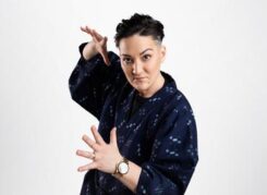 Teiya Kasahara 笠原 貞野 poses in a deep blue robe and holds their hands wide open dramatically while looking right at the camera.