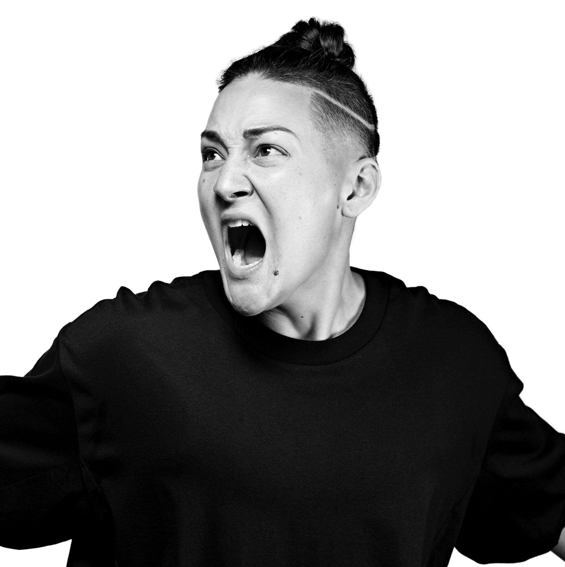 Black and white photo of Teiya Kasahara in a dynamic pose, facing the camera with their mouth open as if they are yelling.