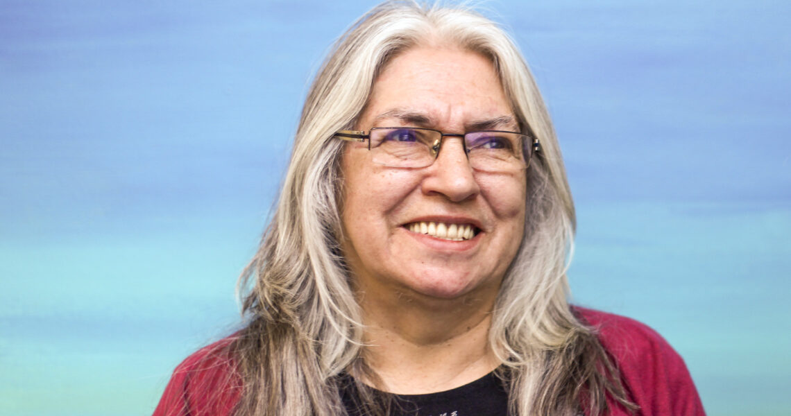 Lee Maracle wears wire glasses and smiles while looking slightly to the right of the camera.