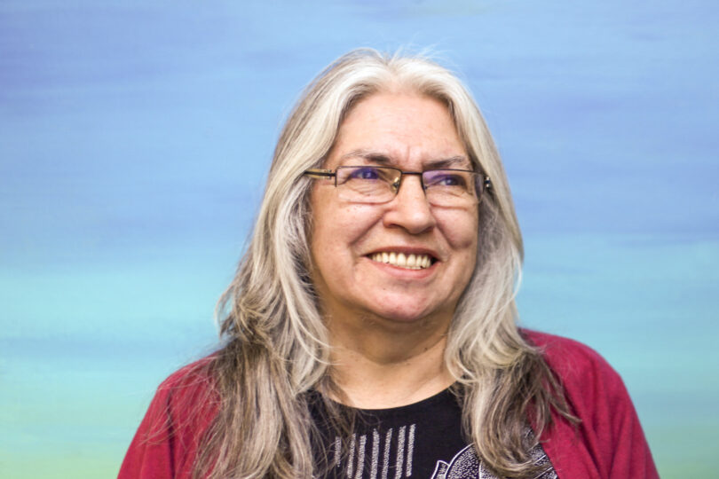 Lee Maracle wears wire glasses and smiles while looking slightly to the right of the camera.